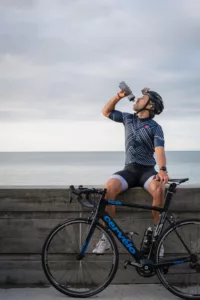 Man on a bike drinking water